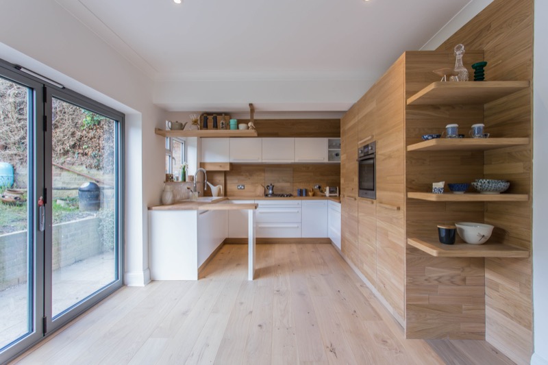 Scandinavian style kitchen with white doors and oak details. Bespoke White and oak kitchen