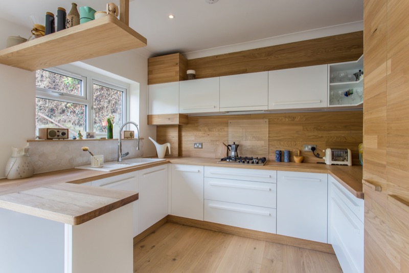 Scandinavian style kitchen with white doors and oak details. Bespoke White and oak kitchen
